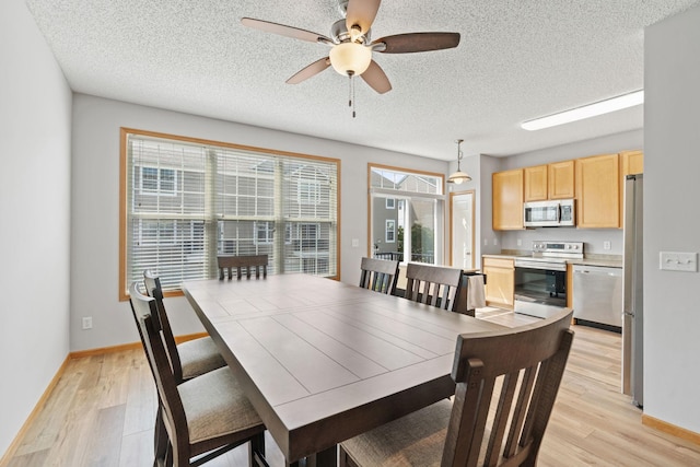4107 Regent Ave N, Robbinsdale, MN 55422 - dining area featuring light wood finished floors, baseboards, a textured ceiling, and ceiling fan