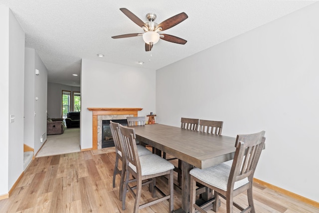 4107 Regent Ave N, Robbinsdale, MN 55422 - dining room featuring light wood-style flooring, a ceiling fan, a tiled fireplace, baseboards, and recessed lighting