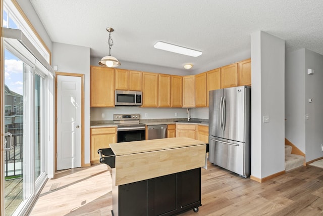 4107 Regent Ave N, Robbinsdale, MN 55422 - kitchen featuring stainless steel appliances, light brown cabinetry, light wood-style floors, a sink, and a textured ceiling