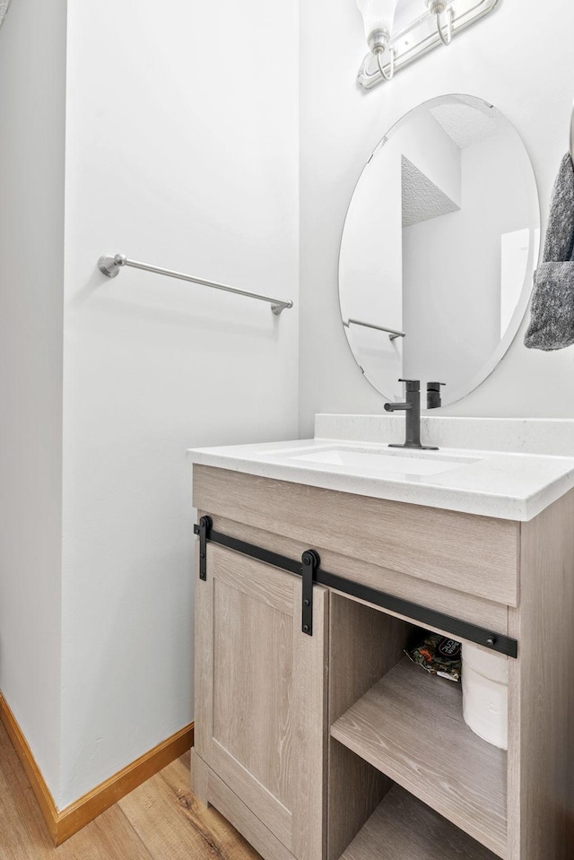 4107 Regent Ave N, Robbinsdale, MN 55422 - bathroom with wood finished floors, vanity, and baseboards