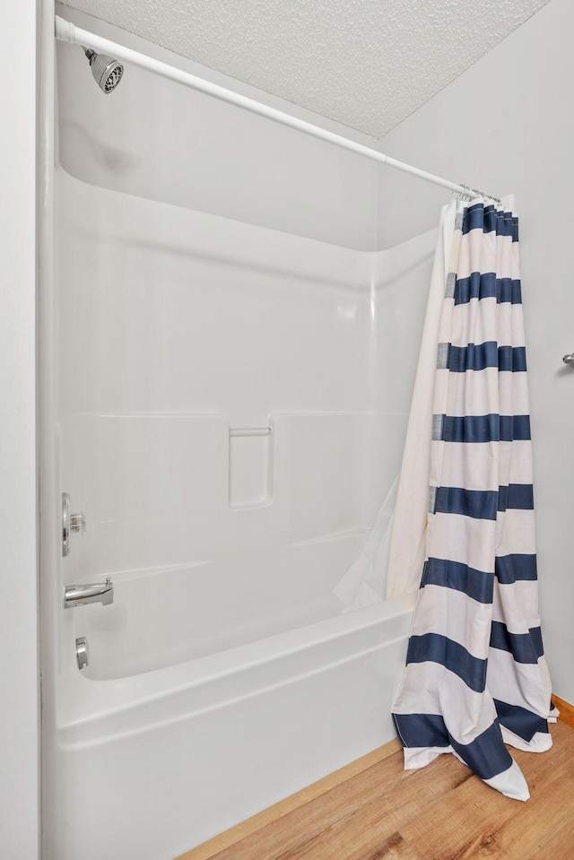 4107 Regent Ave N, Robbinsdale, MN 55422 - bathroom featuring shower / tub combo with curtain, a textured ceiling, and wood finished floors