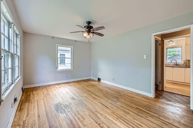 583 Cromwell Ave, Saint Paul, MN 55104 - empty room featuring a sink, light wood-style floors, ceiling fan, and baseboards