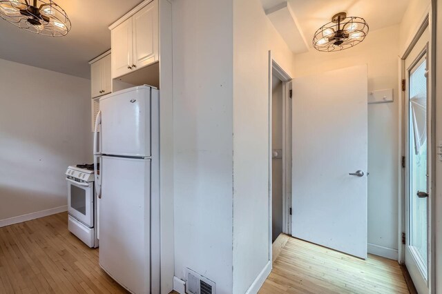 583 Cromwell Ave, Saint Paul, MN 55104 - kitchen featuring white appliances, light wood-style floors, white cabinetry, and baseboards