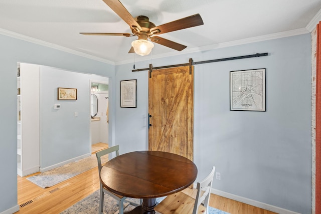 9301 Northwood Pkwy, New Hope, MN 55427 - dining space with a barn door, a ceiling fan, light wood-style floors, and ornamental molding