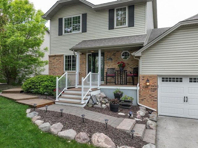 8821 Jonquil Ln N, Maple Grove, MN 55369 - view of front of home featuring brick siding, a shingled roof, and covered porch