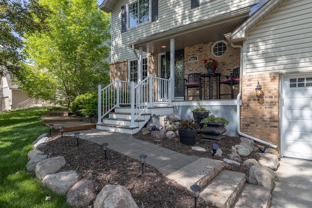 8821 Jonquil Ln N, Maple Grove, MN 55369 - property entrance with brick siding, covered porch, and a garage