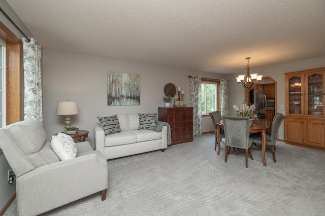 8821 Jonquil Ln N, Maple Grove, MN 55369 - living area featuring a chandelier, light carpet, and a textured ceiling