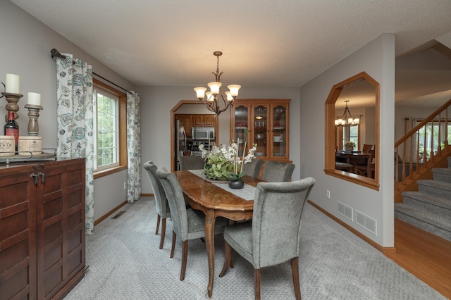 8821 Jonquil Ln N, Maple Grove, MN 55369 - dining space with a chandelier, stairway, baseboards, and light carpet