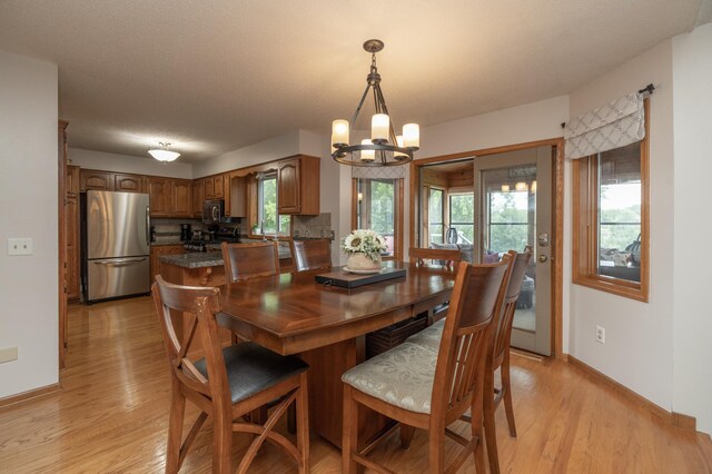 8821 Jonquil Ln N, Maple Grove, MN 55369 - dining space with a chandelier, baseboards, and light wood finished floors