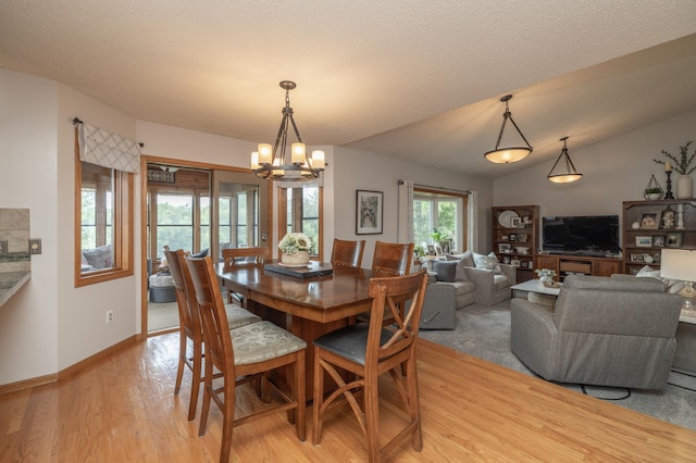 8821 Jonquil Ln N, Maple Grove, MN 55369 - dining area featuring light wood finished floors, a chandelier, baseboards, and lofted ceiling