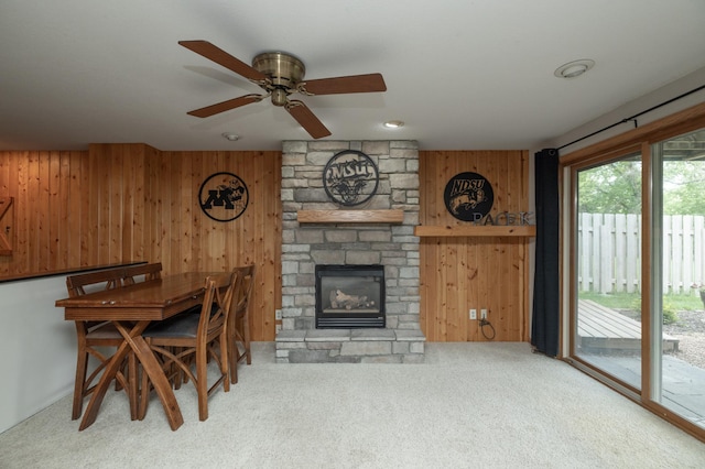 8821 Jonquil Ln N, Maple Grove, MN 55369 - carpeted dining room with wood walls, a fireplace, and ceiling fan