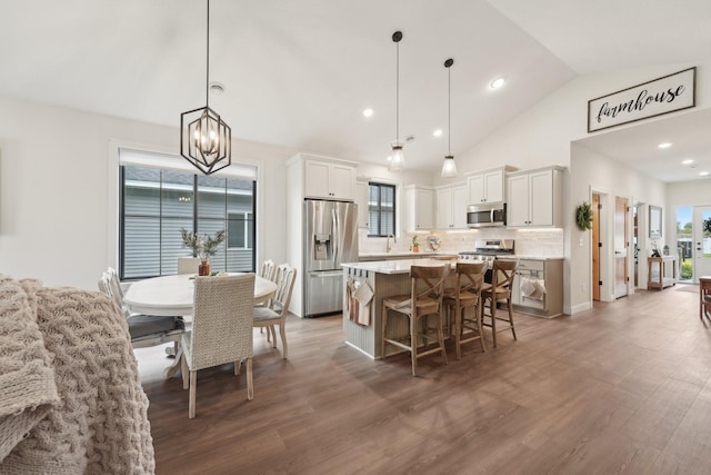 25822 Emerson Ct, Wyoming, MN 55092 - kitchen with stainless steel appliances, a center island, vaulted ceiling, a chandelier, and a breakfast bar