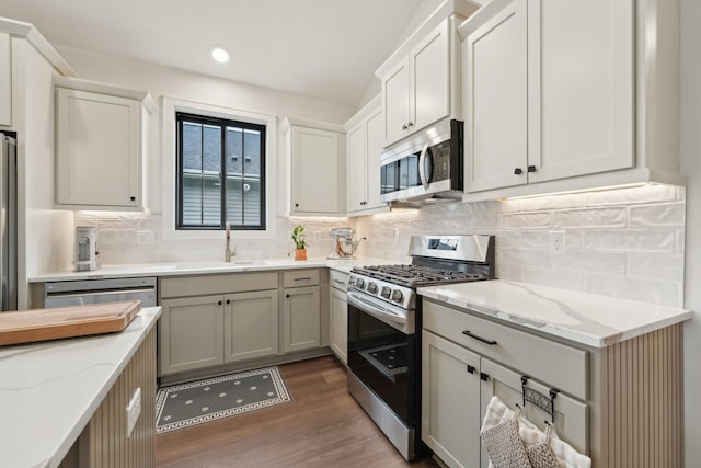 25822 Emerson Ct, Wyoming, MN 55092 - kitchen featuring appliances with stainless steel finishes, wood finished floors, light stone countertops, tasteful backsplash, and recessed lighting