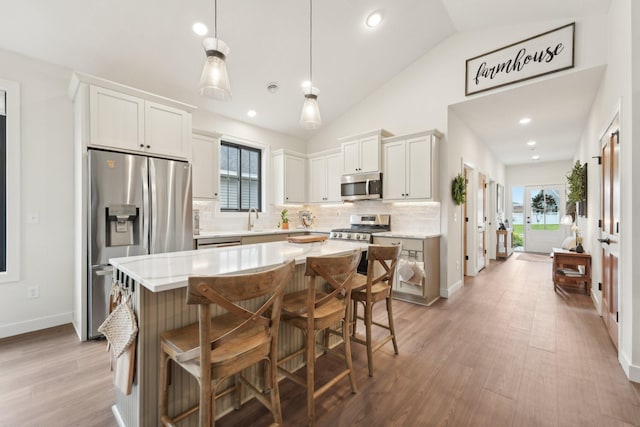 25822 Emerson Ct, Wyoming, MN 55092 - kitchen with appliances with stainless steel finishes, light countertops, tasteful backsplash, a sink, and a kitchen island