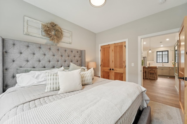 25822 Emerson Ct, Wyoming, MN 55092 - bedroom featuring recessed lighting, ensuite bath, a sink, and light wood finished floors