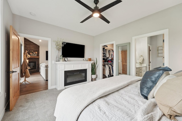 25822 Emerson Ct, Wyoming, MN 55092 - bedroom featuring a glass covered fireplace, a walk in closet, a closet, carpet, and ensuite bathroom