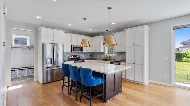 6455 Timber Arch Dr, Chaska, MN 55318 - kitchen with appliances with stainless steel finishes, a sink, backsplash, light wood-style flooring, and recessed lighting