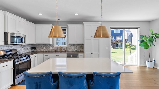 6455 Timber Arch Dr, Chaska, MN 55318 - kitchen with stainless steel appliances, a sink, backsplash, a kitchen island, and recessed lighting
