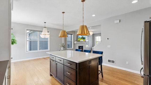 6455 Timber Arch Dr, Chaska, MN 55318 - kitchen with freestanding refrigerator, light wood-style floors, dark brown cabinetry, baseboards, and recessed lighting