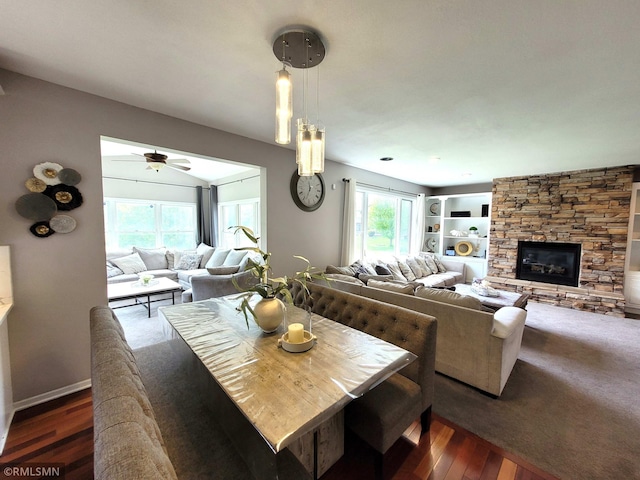 10402 Indiana Ave N, Brooklyn Park, MN 55443 - dining room featuring a ceiling fan, dark wood-style flooring, a fireplace, and baseboards
