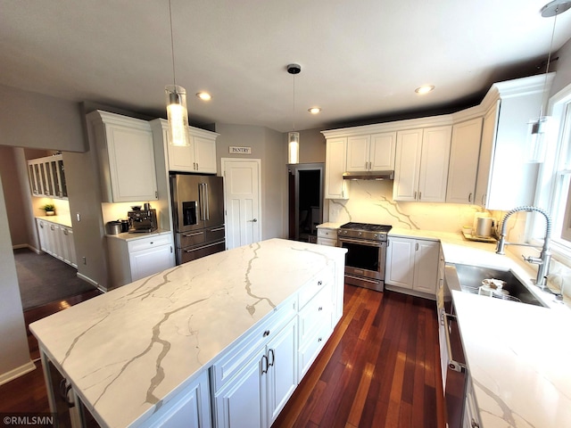 10402 Indiana Ave N, Brooklyn Park, MN 55443 - kitchen with stainless steel appliances, a sink, under cabinet range hood, a kitchen island, and white cabinets