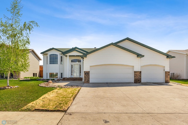 1586 Baywood Dr, Fargo, ND 58078 - view of front of property featuring concrete driveway, a front lawn, an attached garage, and brick siding