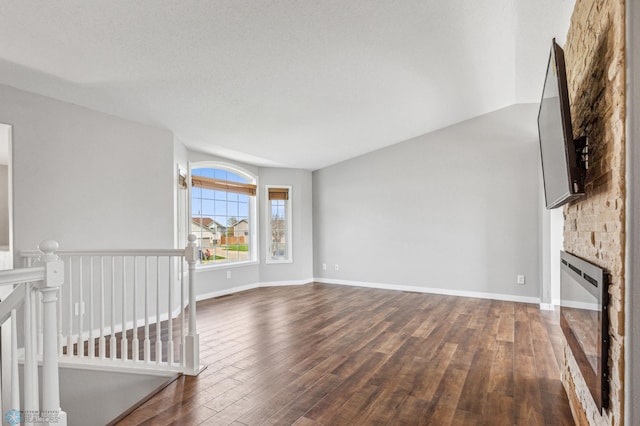 1586 Baywood Dr, Fargo, ND 58078 - unfurnished living room with dark wood finished floors, a glass covered fireplace, and baseboards