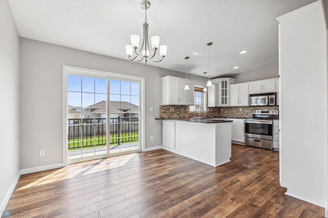1586 Baywood Dr, Fargo, ND 58078 - kitchen with stainless steel appliances, glass insert cabinets, a sink, dark countertops, and a chandelier