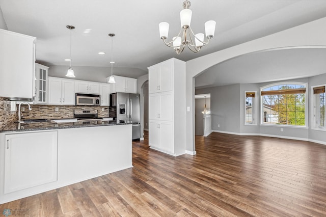 1586 Baywood Dr, Fargo, ND 58078 - kitchen with appliances with stainless steel finishes, a sink, arched walkways, dark stone countertops, and open floor plan