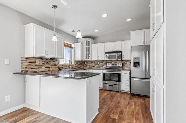 1586 Baywood Dr, Fargo, ND 58078 - kitchen with appliances with stainless steel finishes, a peninsula, decorative backsplash, white cabinetry, and recessed lighting