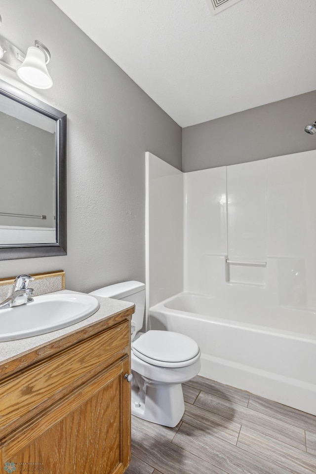 1586 Baywood Dr, Fargo, ND 58078 - bathroom with vanity, toilet, wood finished floors, and shower / bathtub combination