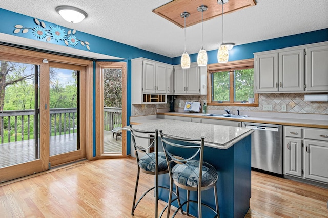 4985 142nd Ln NW, Ramsey, MN 55303 - kitchen featuring dishwasher, healthy amount of natural light, light wood-style flooring, a textured ceiling, and decorative backsplash