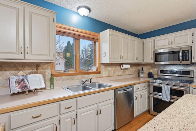 4985 142nd Ln NW, Ramsey, MN 55303 - kitchen featuring appliances with stainless steel finishes, light countertops, light wood-style floors, white cabinets, and a textured ceiling