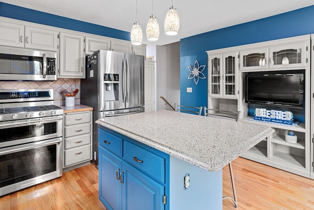 4985 142nd Ln NW, Ramsey, MN 55303 - kitchen with appliances with stainless steel finishes, blue cabinets, white cabinets, and light wood finished floors