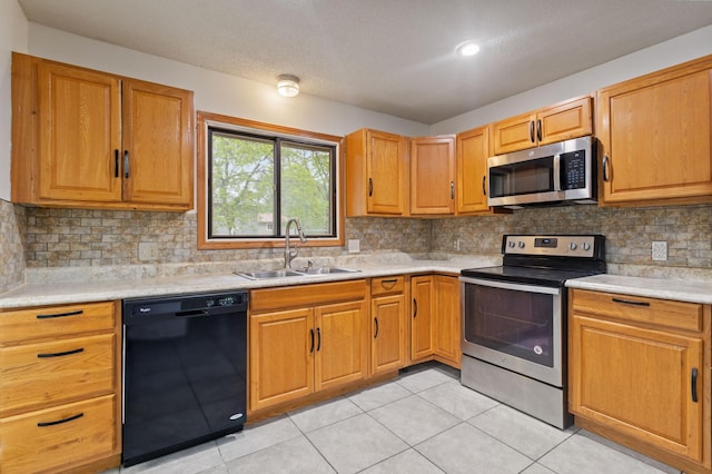2908 81st Ave N, Brooklyn Park, MN 55444 - kitchen featuring appliances with stainless steel finishes, a sink, light countertops, light tile patterned floors, and backsplash