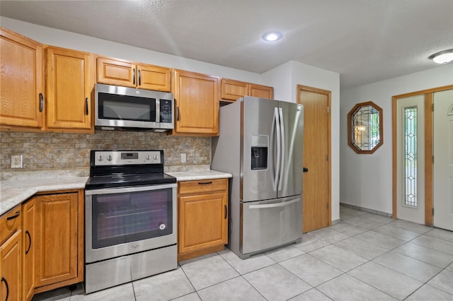 2908 81st Ave N, Brooklyn Park, MN 55444 - kitchen with appliances with stainless steel finishes, light countertops, tasteful backsplash, light tile patterned floors, and a textured ceiling