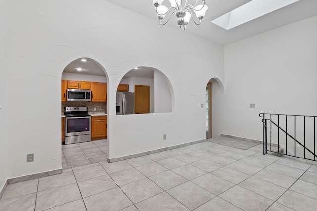 2908 81st Ave N, Brooklyn Park, MN 55444 - unfurnished room with a skylight, light tile patterned floors, a chandelier, stairs, and baseboards