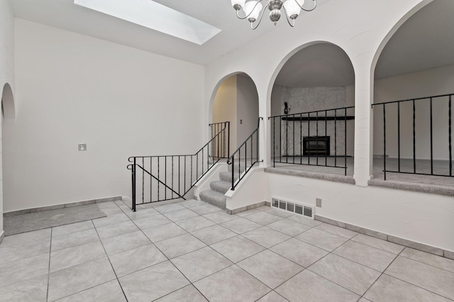 2908 81st Ave N, Brooklyn Park, MN 55444 - tiled spare room with a skylight, stairway, a chandelier, and a fireplace