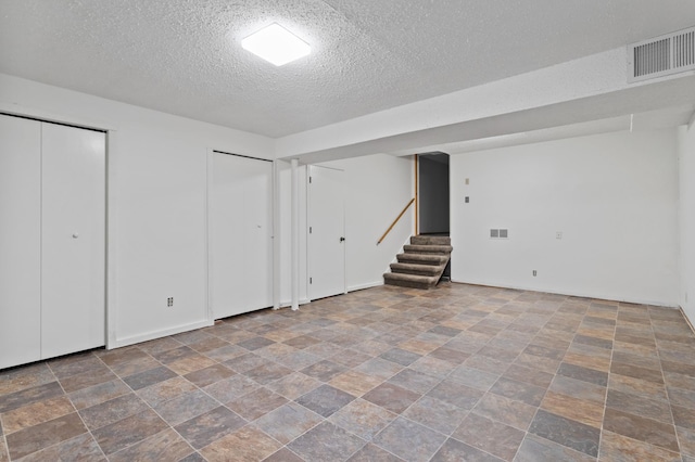 2908 81st Ave N, Brooklyn Park, MN 55444 - finished below grade area with a textured ceiling, stairway, and stone finish floors