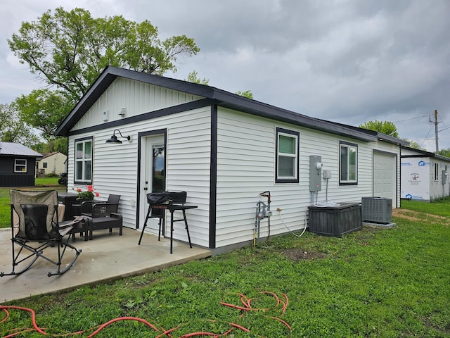 2011/2 10th Ave SE, Pipestone, MN 56164 - back of house with central air condition unit, a yard, and a patio area
