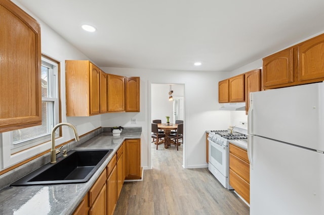 609 2nd Ave NE, Sleepy Eye, MN 56085 - kitchen featuring white appliances, a sink, under cabinet range hood, wood finished floors, and recessed lighting