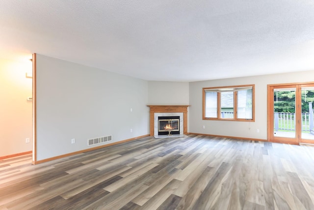 11622 Rio Loma Ln, Burnsville, MN 55337 - unfurnished living room featuring wood finished floors, a fireplace with flush hearth, baseboards, and a textured ceiling