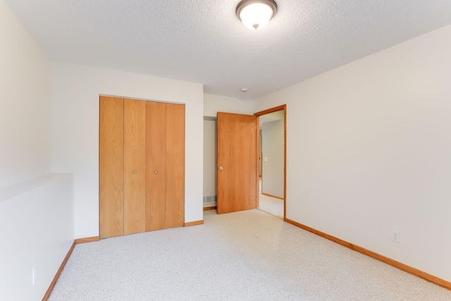 11622 Rio Loma Ln, Burnsville, MN 55337 - unfurnished bedroom with a closet, baseboards, a textured ceiling, and carpet floors