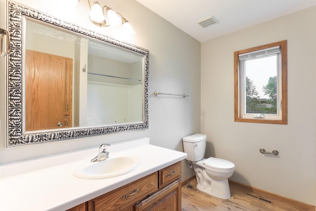 11622 Rio Loma Ln, Burnsville, MN 55337 - bathroom featuring wood finished floors, toilet, vanity, a shower, and baseboards