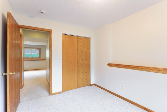 11622 Rio Loma Ln, Burnsville, MN 55337 - unfurnished bedroom featuring light colored carpet, a closet, baseboards, and a textured ceiling