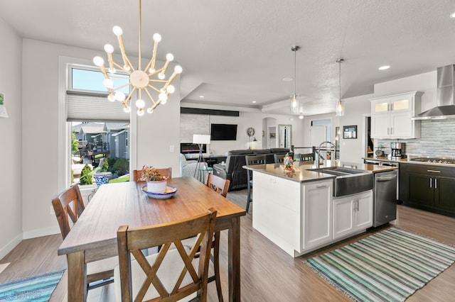 3784 Bell Blvd E, West Fargo, ND 58078 - kitchen with a sink, wall chimney exhaust hood, stainless steel appliances, decorative backsplash, and wood finished floors