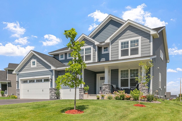 12905 Jewell Cir NE, Blaine, MN 55449 - craftsman house featuring covered porch, stone siding, asphalt driveway, and a front lawn