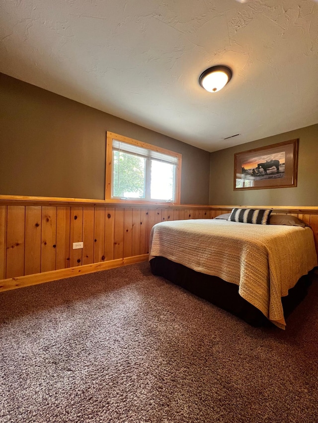 17300 Baseline Ave, Sand Creek Twp, MN 55352 - bedroom featuring wainscoting, carpet, and wooden walls