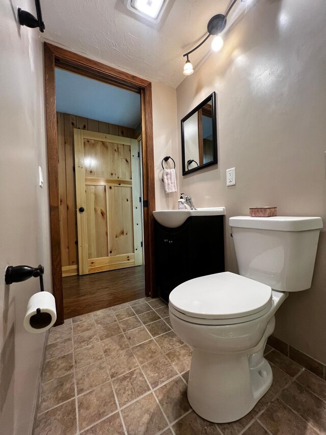 17300 Baseline Ave, Sand Creek Twp, MN 55352 - bathroom featuring vanity, toilet, baseboards, and track lighting