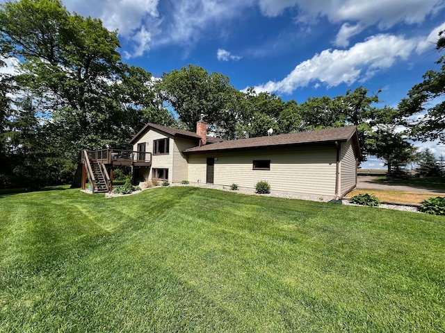 17300 Baseline Ave, Sand Creek Twp, MN 55352 - rear view of house with stairway, a wooden deck, a lawn, and a chimney